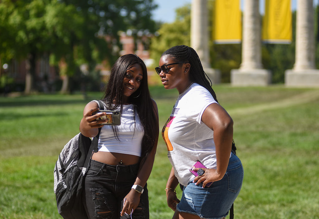 MU students Mayah Clayton and Jaylan Wright take a selfie in front of the Columns at Francis Quadrangle